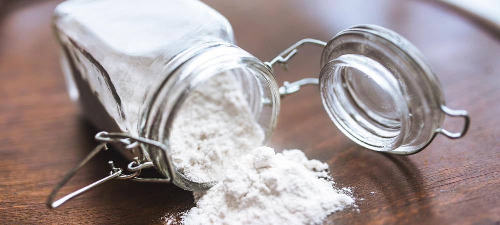Borax Powder Spilling from a Glass Container on Wooden Table